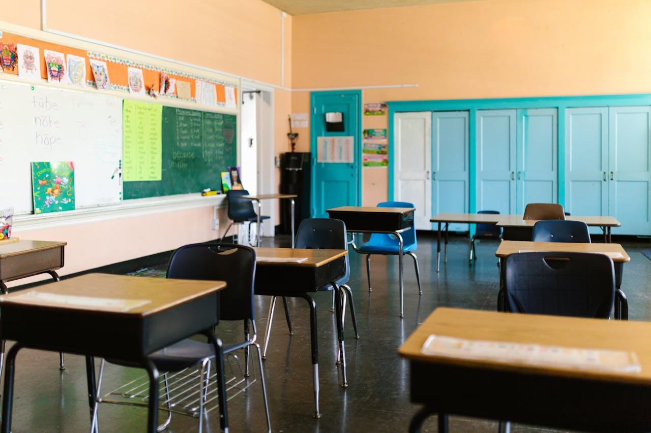 Home Bright and colorful empty classroom with desks, blackboard, and educational materials.